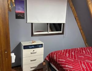 a bedroom with a bed and a dresser and a mirror at Los boldos in Concón