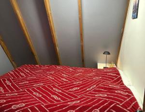 a bed with a red comforter in a room at Los boldos in Concón