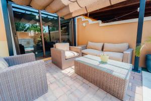 a patio with wicker chairs and a table at Gold coast beautiful house with private pool in Palm-Eagle Beach
