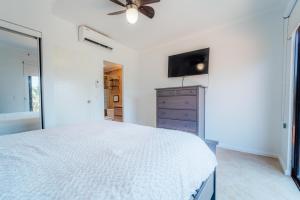 a white bedroom with a bed and a ceiling fan at Gold coast beautiful house with private pool in Palm-Eagle Beach +40 photos