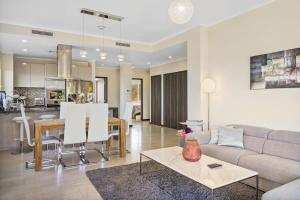 a living room and kitchen with a couch and a table at LUXURIOUS APARTMENT IN LEVENT FRONT EAGLE BEACH in Palm-Eagle Beach