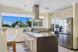 a kitchen with a large island with a stainless steel refrigerator at LUXURIOUS APARTMENT IN LEVENT FRONT EAGLE BEACH in Palm-Eagle Beach