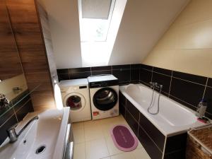 a small bathroom with a washing machine and a tub at Apartmán Urban Kubín in Dolný Kubín