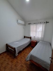 a bedroom with two beds and a window at Departamento Blach in Cafayate