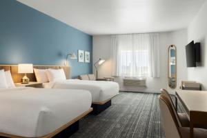 a hotel room with two beds and a desk at TownePlace Suites by Marriott Minot in Minot +64 photos