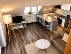 a living room with a couch and a kitchen at Apartmán Urban Kubín in Dolný Kubín