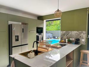 a kitchen with green walls and a counter with a sink at Villa Aloa Private pool in Les Abymes