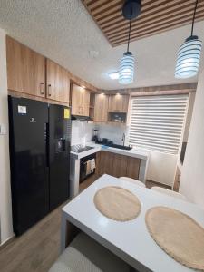 a kitchen with a table and a black refrigerator at Modern and cozy in Riobamba in Riobamba