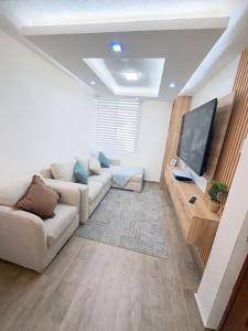 a living room with a couch and a flat screen tv at Modern and cozy in Riobamba in Riobamba +5 photos