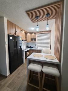 a kitchen with a table and a black refrigerator at Modern and cozy in Riobamba in Riobamba
