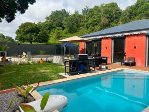 a backyard with a pool and a house at Villa Aloa Private pool in Les Abymes