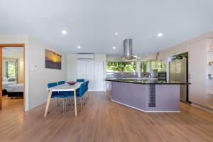 a kitchen and living room with a table and chairs at Getaway Ocean Views KIDS STAY FREE in Airlie Beach