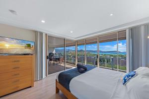 a bedroom with a large bed and a balcony at Getaway Ocean Views KIDS STAY FREE in Airlie Beach +46 photos