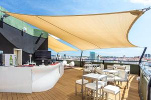 a rooftop bar with tables and chairs on a roof at Holiday Inn Lisbon by IHG in Lisbon