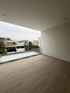 a room with a large white wall and a wooden floor at SM residence in Lahore