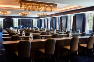 a row of tables and chairs in a room with chandeliers at Kimpton Cardinal Hotel by IHG in Winston-Salem