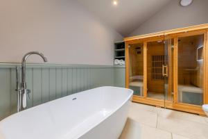 a large white bath tub in a bathroom at 2 Bed in Leyburn oc-g0099 in Constable Burton +20 photos