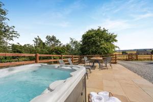 a hot tub on a patio with a table and chairs at 2 Bed in Leyburn oc-g0099 in Constable Burton