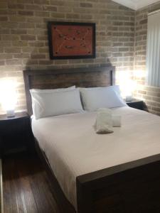 a bedroom with a large bed with two lamps at Flora Parade 6 in Tuncurry +11 photos