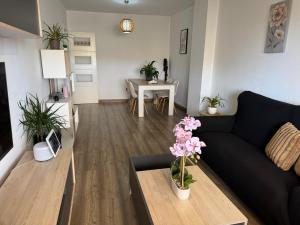 a living room with a black couch and a table at Acogedor Apartamento in Almerimar