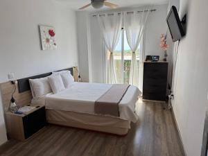 a bedroom with a large bed and a window at Acogedor Apartamento in Almerimar