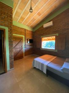 a bedroom with a bed and a brick wall at Pousada do Chicó in São Roque de Minas +62 photos