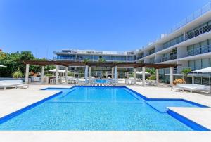 a swimming pool in front of a building at Magia Multi Listings in Playa del Carmen