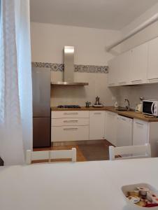 a kitchen with white cabinets and a counter top at Room Bed Garden in Berra