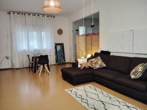 a living room with a black couch and a table at Room Bed Garden in Berra