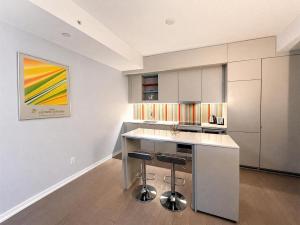a kitchen with a counter and two bar stools at The C Park Hotel and Suites in Toronto