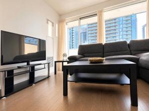 a living room with a couch and a tv at The C Park Hotel and Suites in Toronto