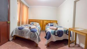a bedroom with two beds with blue and white blankets at Tango in Sucre