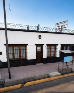 a white building with windows and a wooden door at Dorrego Apart 3 in Guaymallen +2 photos