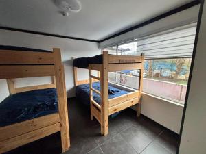 two bunk beds in a room with a window at Raiza Hotel in Concepción