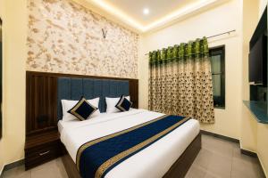 a bedroom with a large bed in a room at Hotel Urban Stay - Mathura in Mathura