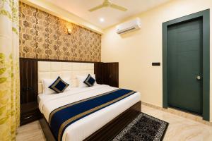 a bedroom with a bed with a green door at Hotel Urban Stay - Mathura in Mathura