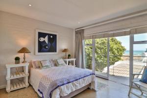 a bedroom with a bed and a view of the ocean at Vinho Verde Splendid Sea View Jacuzzi in Franskraalstrand
