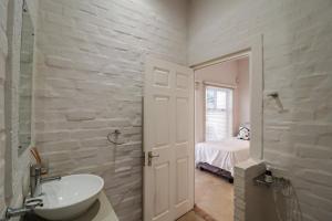 a white bathroom with a sink and a bedroom at Vinho Verde Splendid Sea View Jacuzzi in Franskraalstrand +45 photos