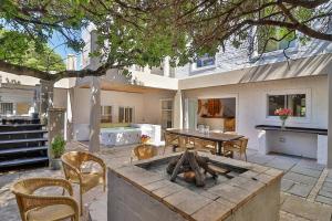a backyard with a table and a fire pit at Vinho Verde Splendid Sea View Jacuzzi in Franskraalstrand