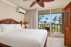 a bedroom with a white bed and a balcony at Aston Islander On The Beach in Kapaa +104 photos