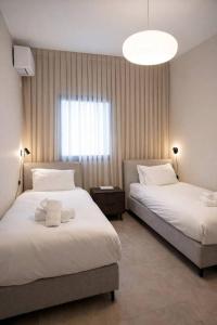 a hotel room with two beds and a large window at 2 Br Apartment In Savyoney Tower W Room in Jerusalem
