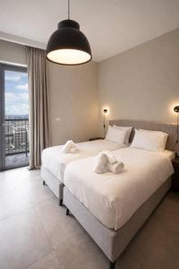 a bedroom with a large bed and a large window at 2 Br Apartment In Savyoney Tower W Room in Jerusalem