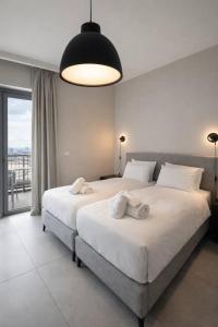 a bedroom with two beds and a large window at 2 Br Apartment In Savyoney Tower W Room in Jerusalem