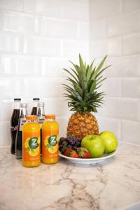 a plate of fruit on a counter with a pineapple and oranges at 2 Br Apartment In Savyoney Tower W Room in Jerusalem
