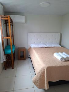 a bedroom with a bed with two towels on it at Casinha Virtuosa in Monte Sião +21 photos