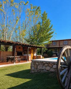 a building with a stone wall and a wooden wheel at Dorrego Apart 3 in Guaymallen