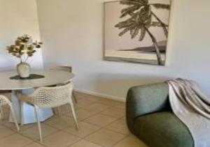 a dining room with a table and a green chair at Nature Meets City on Mint in Townsville
