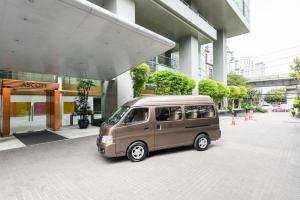 a small van parked in front of a building at Ascott Sathorn Bangkok in Bangkok