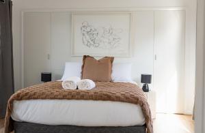 a bedroom with a bed with two towels on it at Hamptons on the Bay in Swansea
