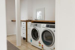 a laundry room with a washer and dryer at Hamptons on the Bay in Swansea